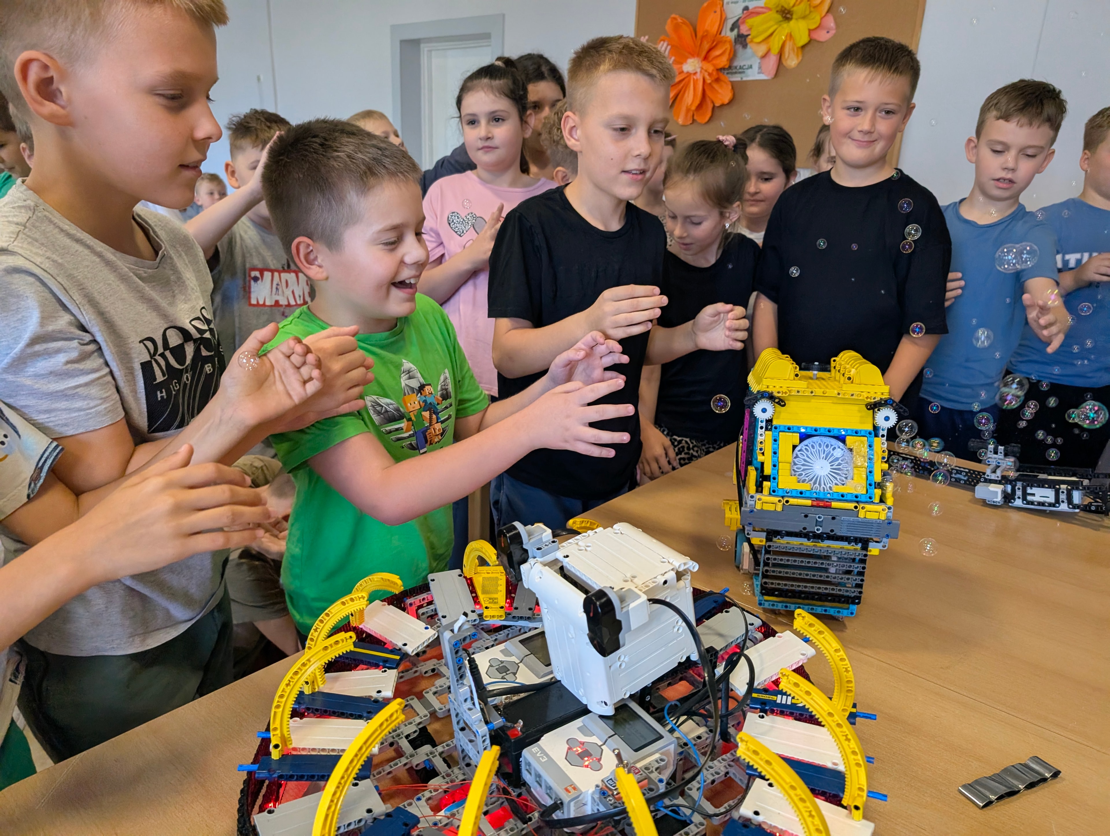 Dzieci obserwują roboty LEGO i pokaz baniek mydlanych